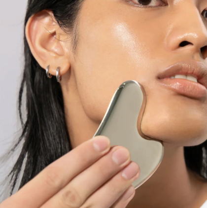 Woman using stainless steel Gua Sha