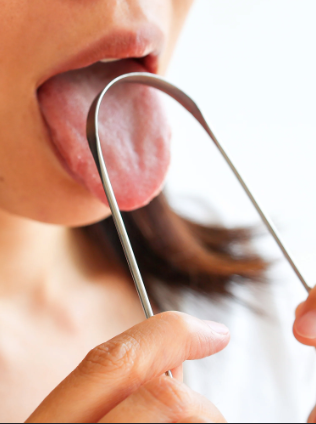 Person using a stainless steel tongue scraper
